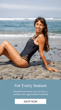 Black one piece swimsuit with crisscross detail and scoop back, model on beach in san diego black swimsuit